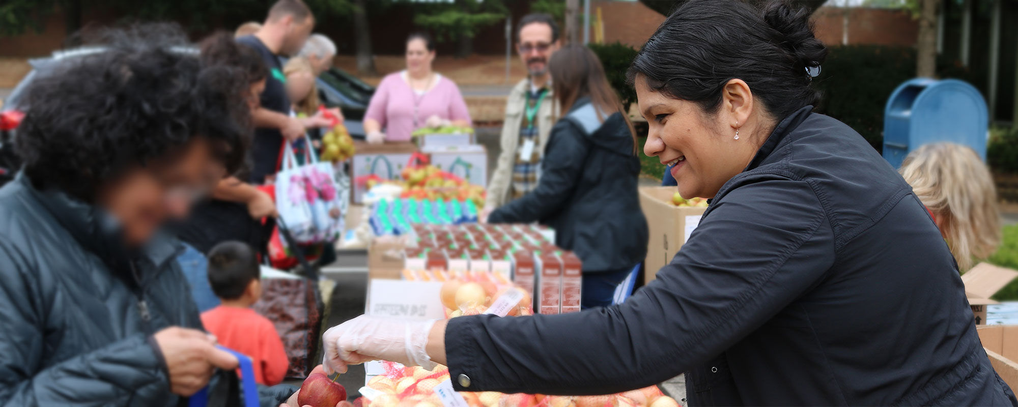 Woman handing out food at the Free Food Market