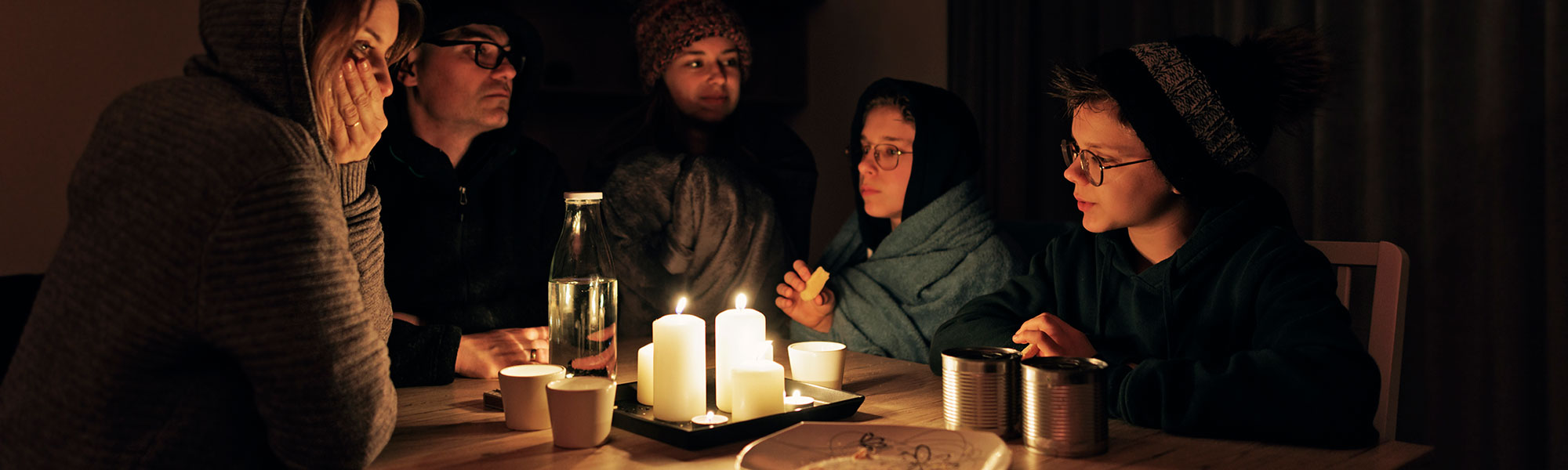 Family sitting at the dining room table in the dark during a power outage