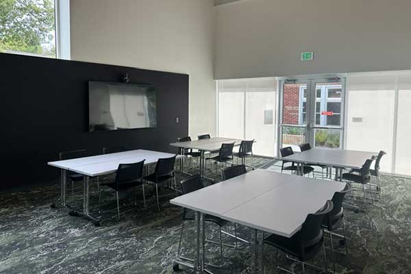 room with tables and chairs and tv screen