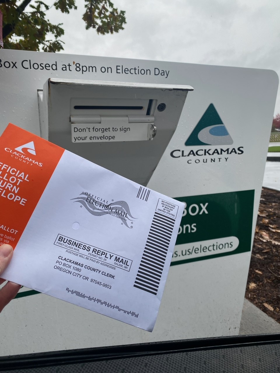 A voter returns their ballot to the Wilsonville official ballot drop site.