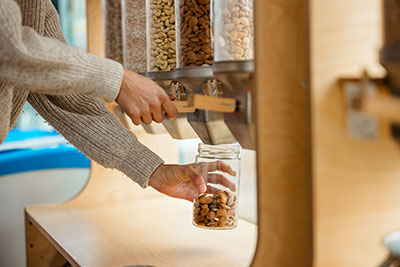 person filling a jar with nuts