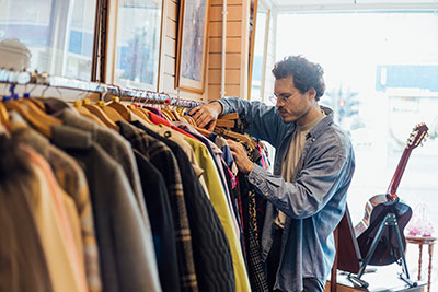 man shopping for clothes at a secondhand store