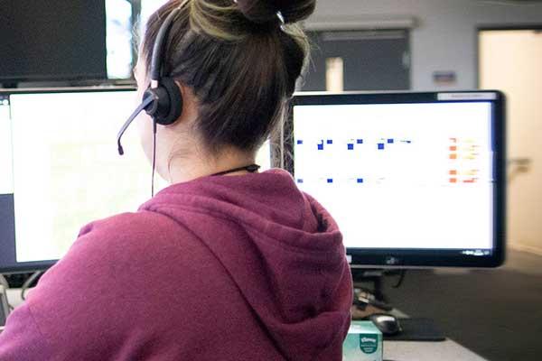 nurse sitting in front of computer screen with headphones on