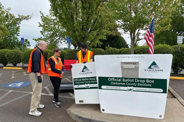 Election workers retrieve ballots from an official ballot drop site on Election Day.
